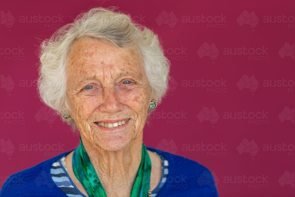 head and shoulders of vivacious octogenarian smiling and looking at camera - Australian Stock Image