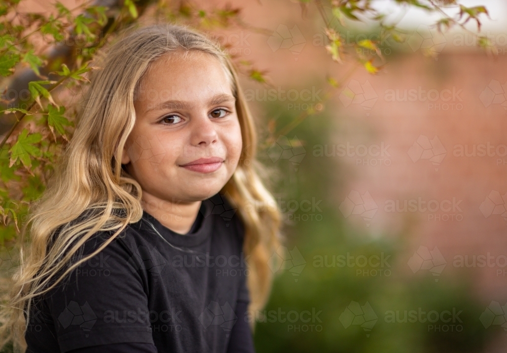 head and shoulders of young aboriginal girl with long blonde hair - Australian Stock Image