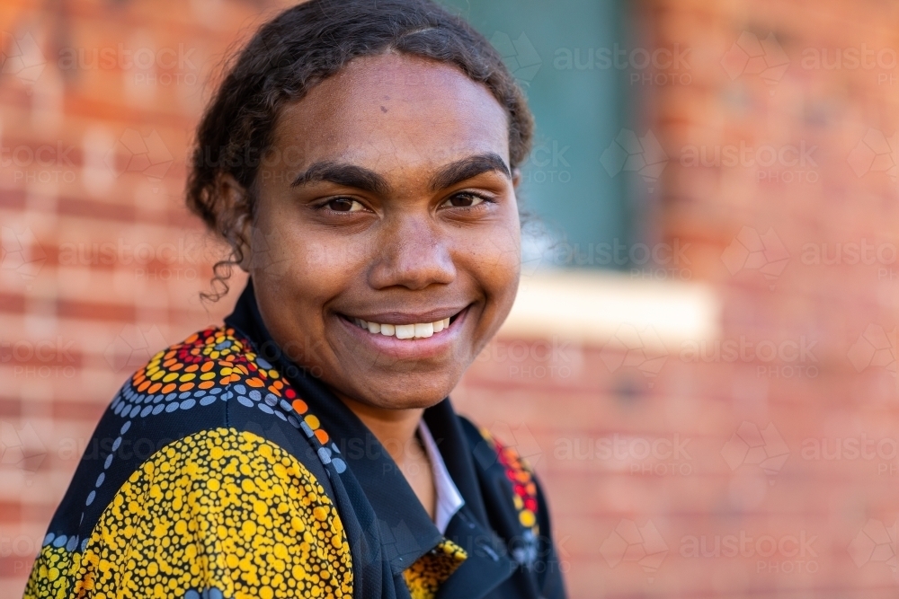 head and shoulders of young aboriginal woman with hair tied back - Australian Stock Image