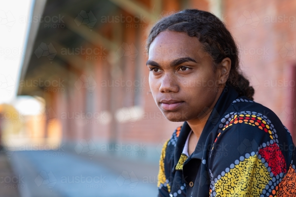 head and shoulders of young aboriginal woman with hair tied back - Australian Stock Image