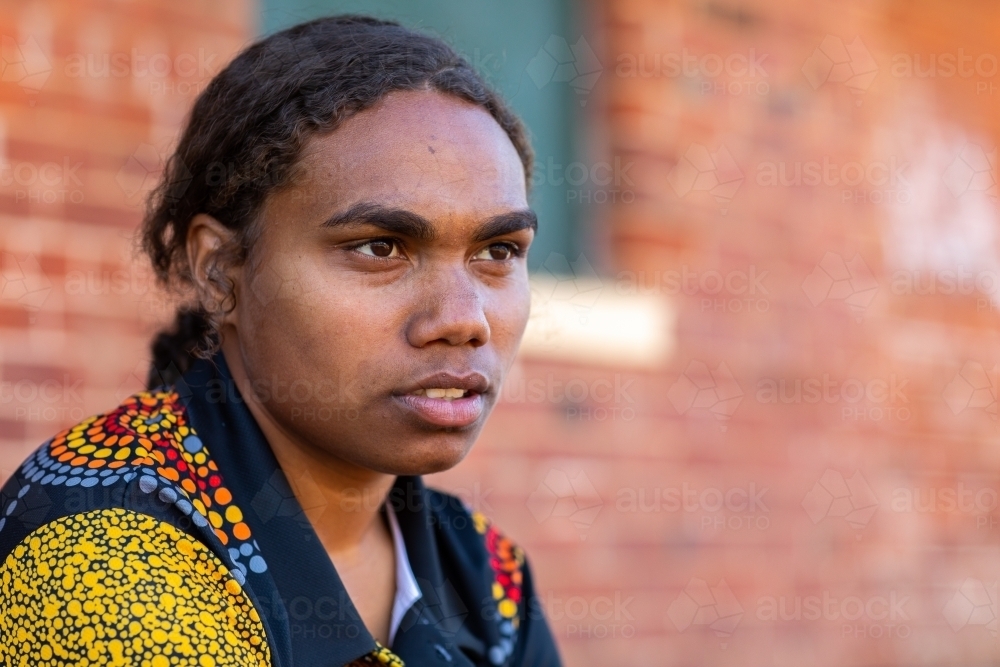 head and shoulders of young aboriginal woman with hair tied back - Australian Stock Image