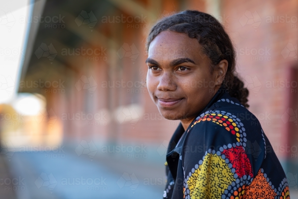 head and shoulders of young aboriginal woman with hair tied back - Australian Stock Image
