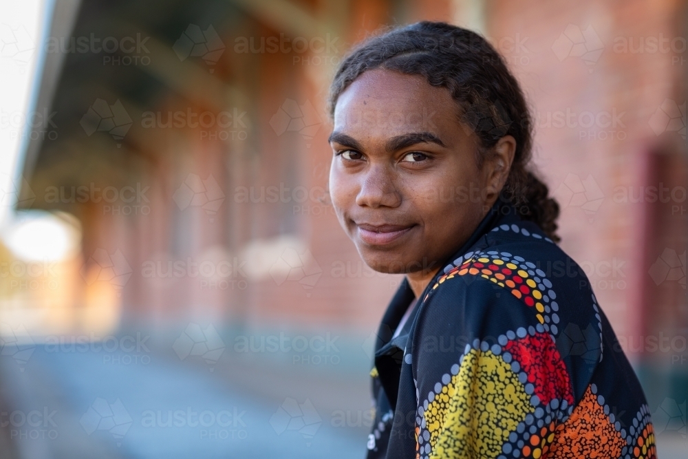 head and shoulders of young aboriginal woman with hair tied back - Australian Stock Image