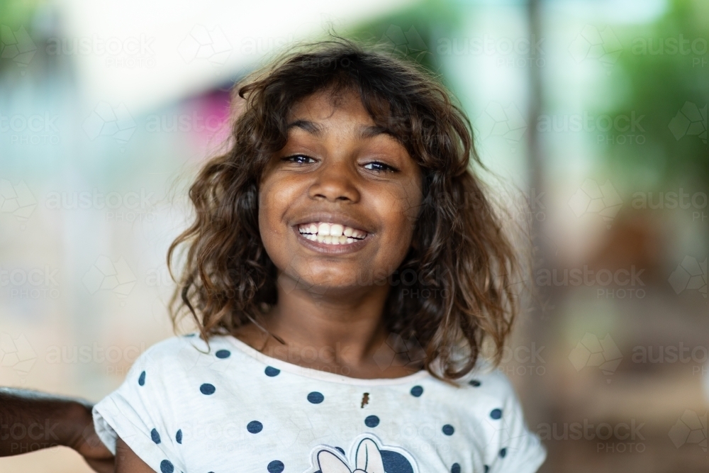 head and shoulders of young girl with big smile looking at the camera - Australian Stock Image