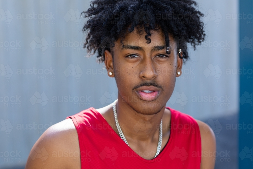 head and shoulders of young man with a mop of black hair looking intently - Australian Stock Image
