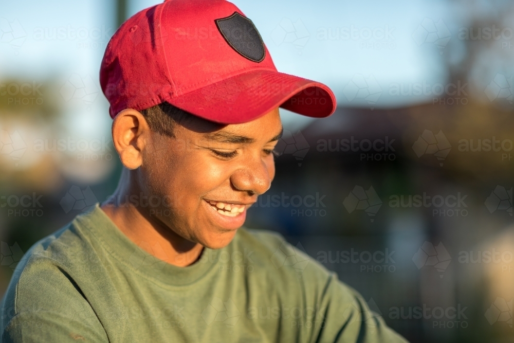 head and shoulders of young teen boy wearing red cap - Australian Stock Image