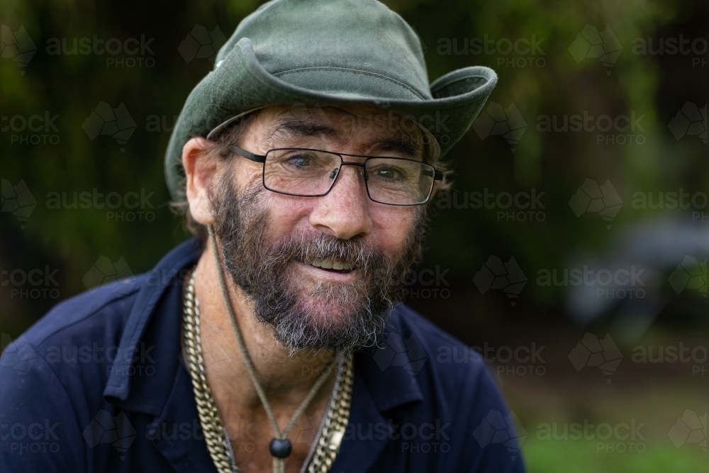 Head and shoulders portrait of a homeless man smiling - Australian Stock Image