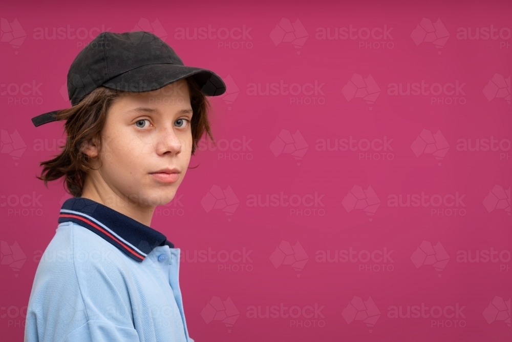 head and shoulders view of school kid against pink background - Australian Stock Image