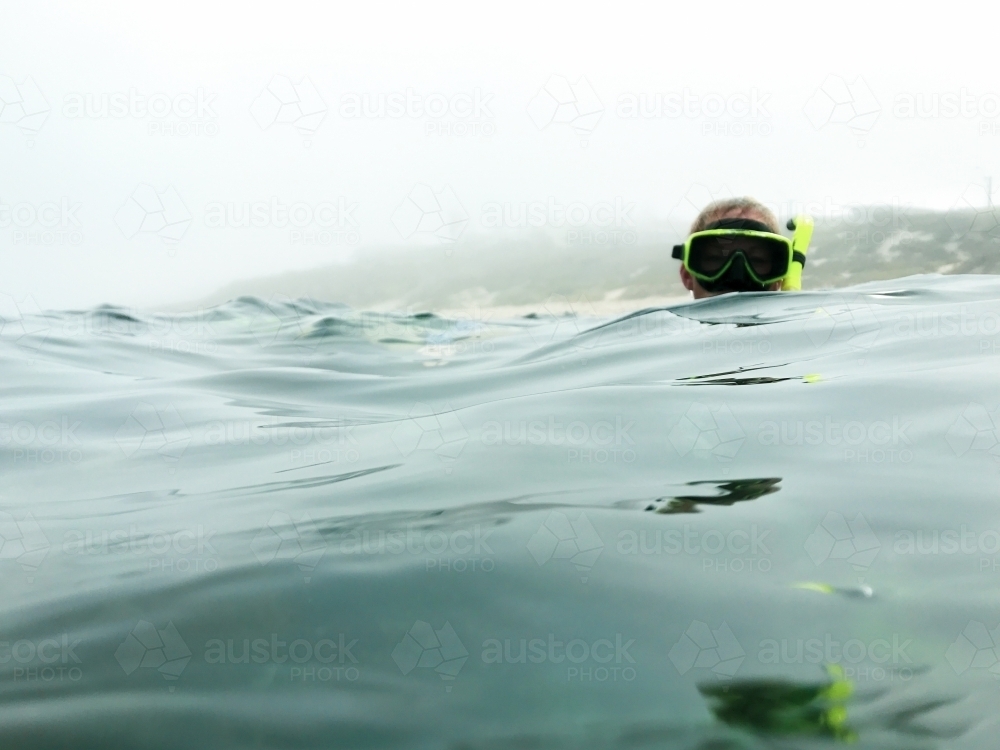 Head of a snorkeler just above the water - Australian Stock Image