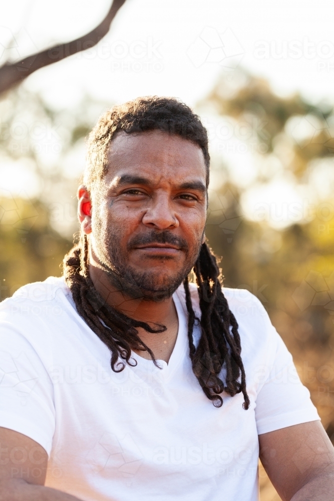 Headshot of serious expression on face of First Nations Australian man - Australian Stock Image