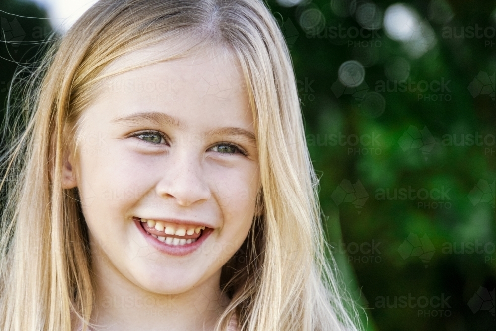 Headshot of six year old smiling looking away - Australian Stock Image