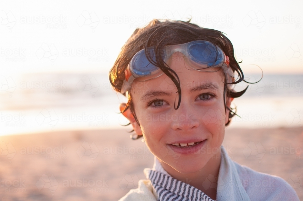 Headshot of young boy on beach after swimming - Australian Stock Image