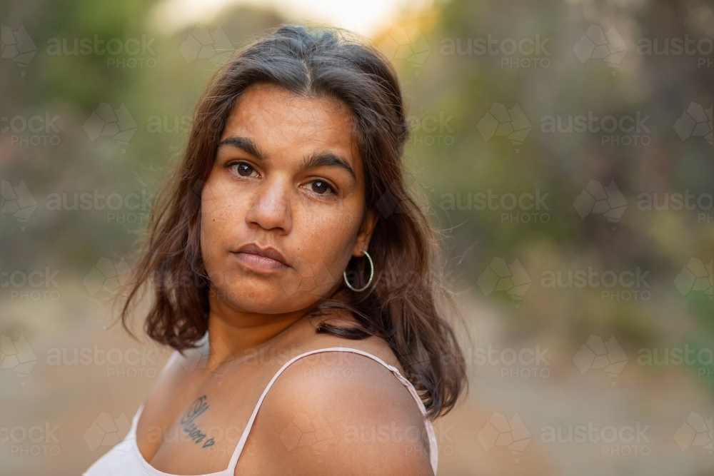 Headshot of young woman with wavy, brown hair with a blurry background - Australian Stock Image