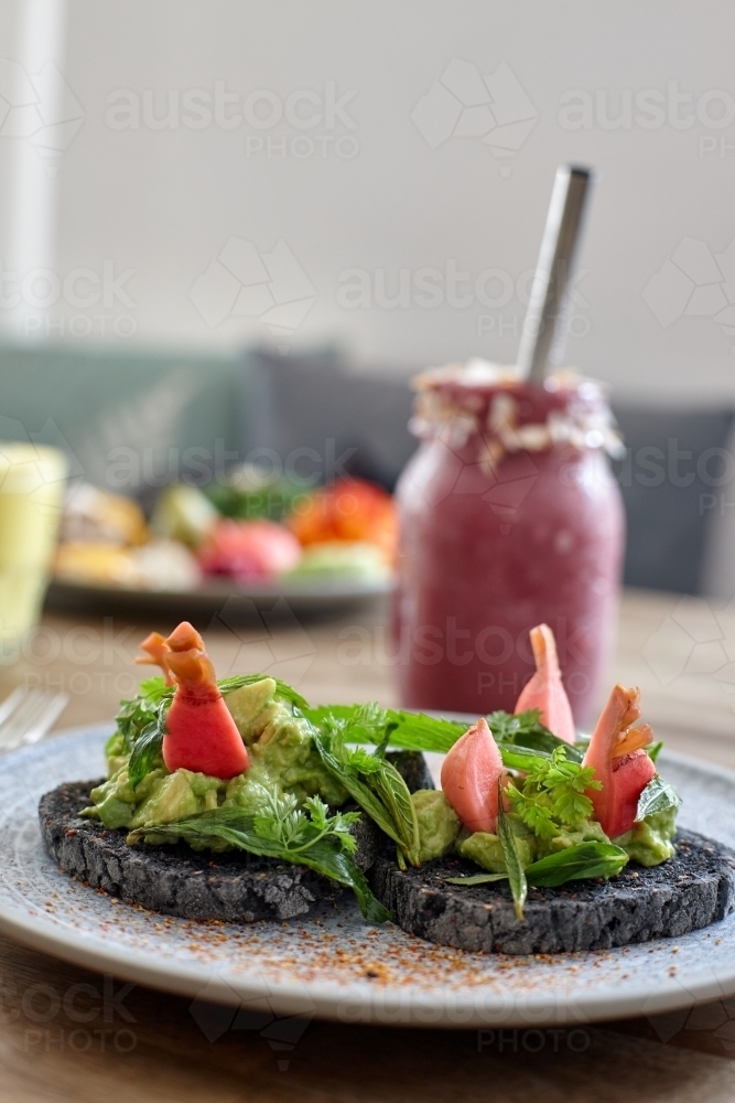 Healthy avocado on toast and smoothie ready to eat - Australian Stock Image