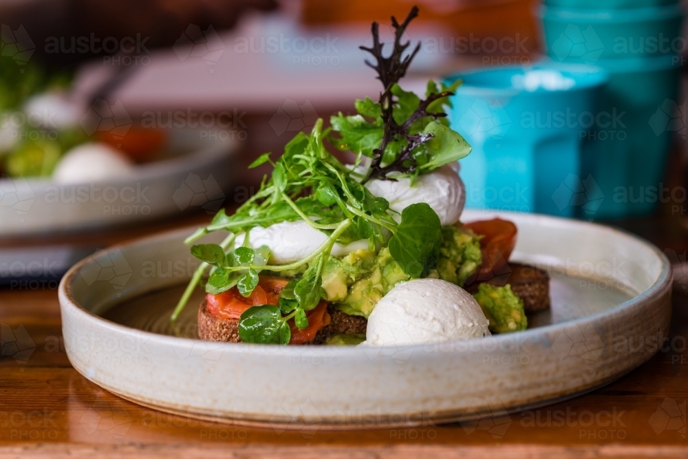 healthy breakfast with egg, avo, goat curd and greens - Australian Stock Image