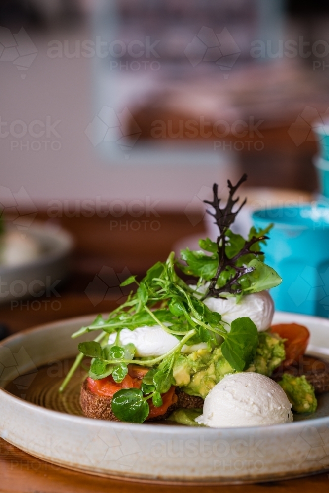 healthy breakfast with egg, avo, goat curd and greens - Australian Stock Image