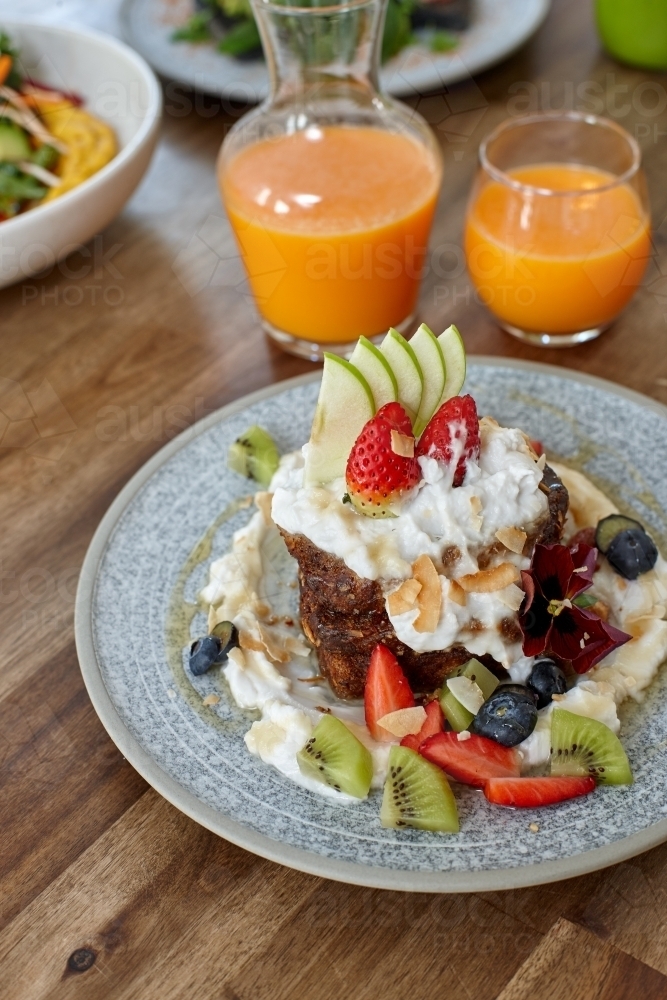 Healthy organic vegan food and drinks on wooden table - Australian Stock Image