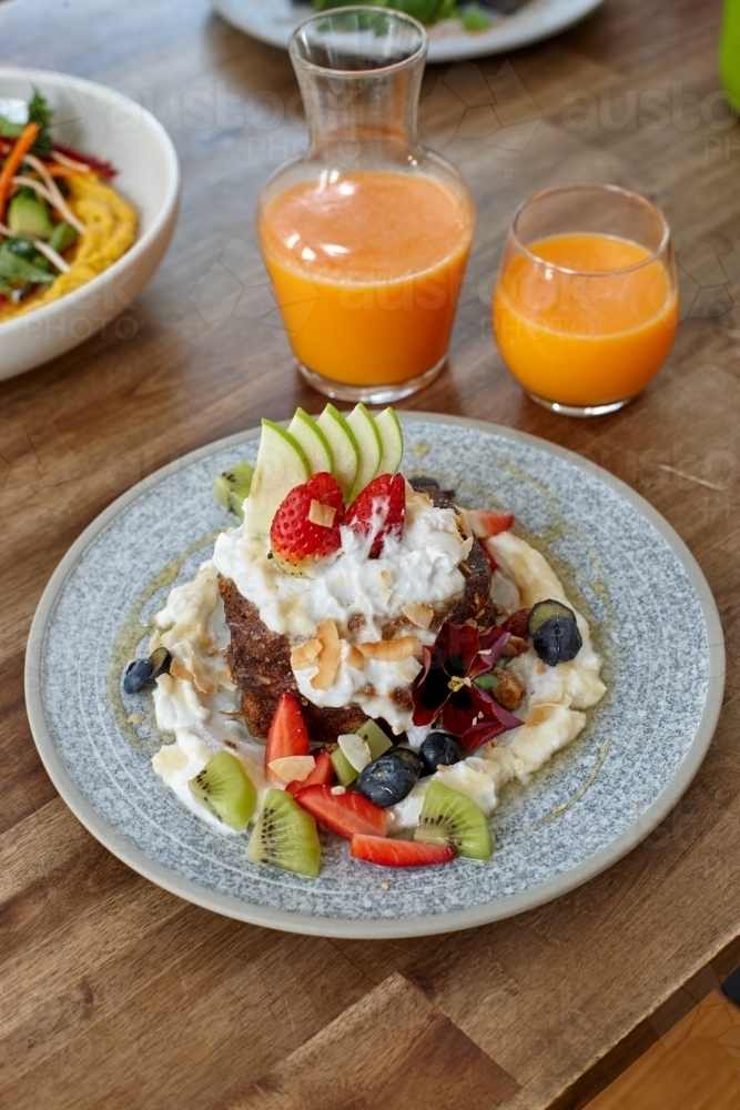 Healthy organic vegan food and drinks on wooden table - Australian Stock Image