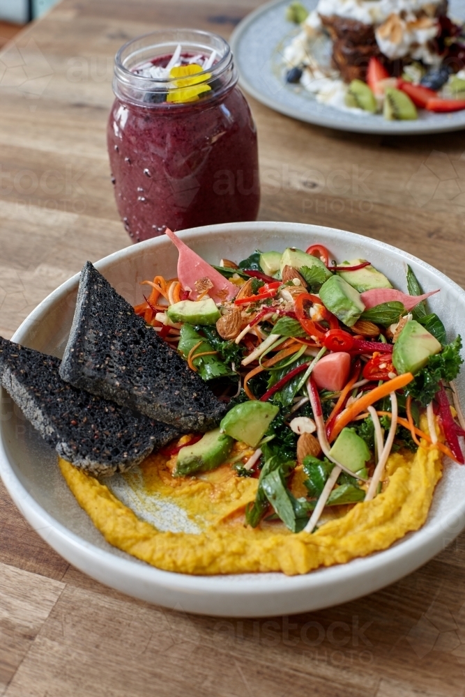 Healthy organic vegan food and drinks on wooden table - Australian Stock Image