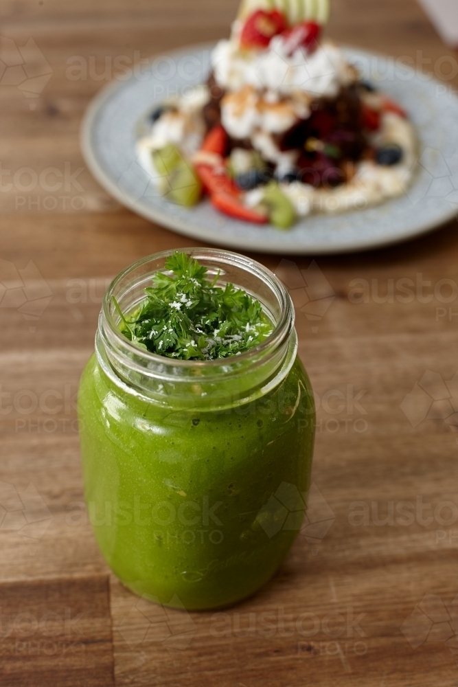 Healthy organic vegan food and drinks on wooden table - Australian Stock Image
