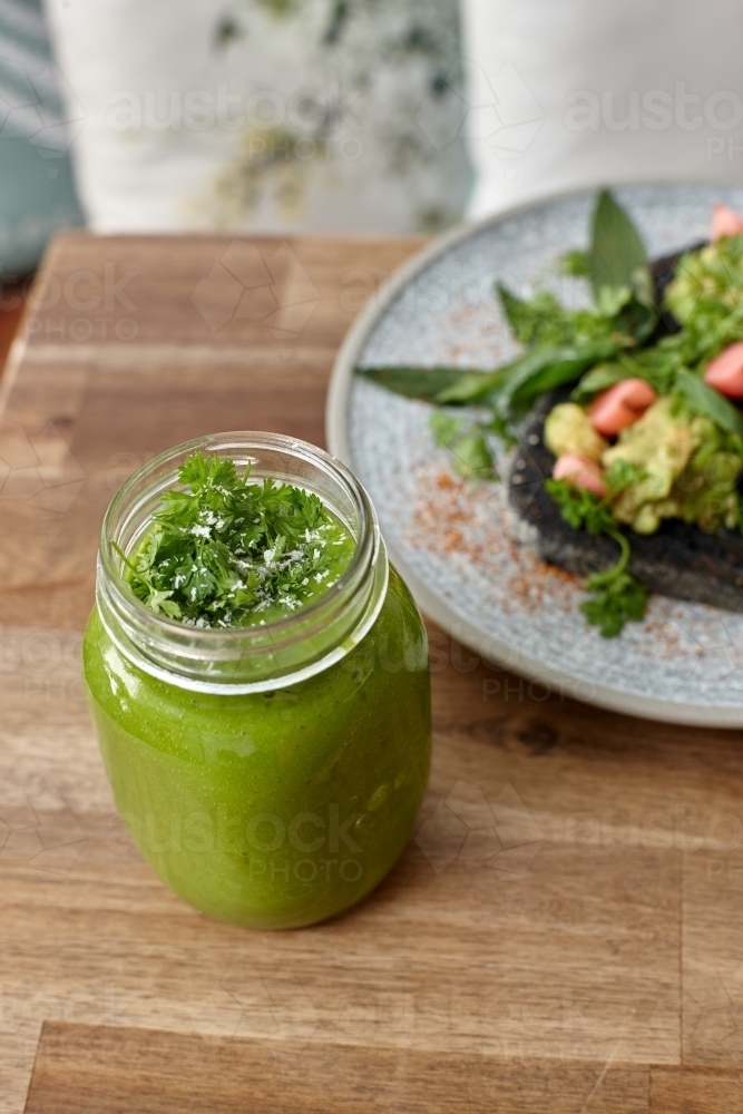 Healthy organic vegan food and drinks on wooden table - Australian Stock Image