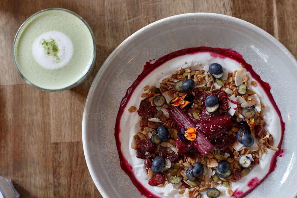 Healthy porridge served with hot beverage in vegetarian cafe - Australian Stock Image