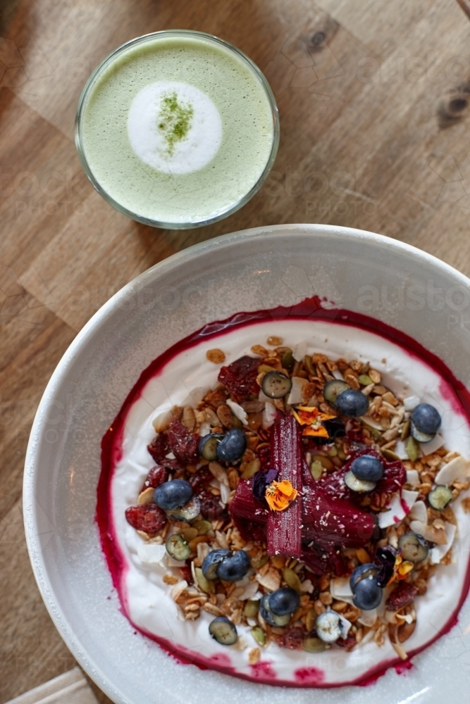 Healthy porridge served with hot beverage in vegetarian cafe - Australian Stock Image