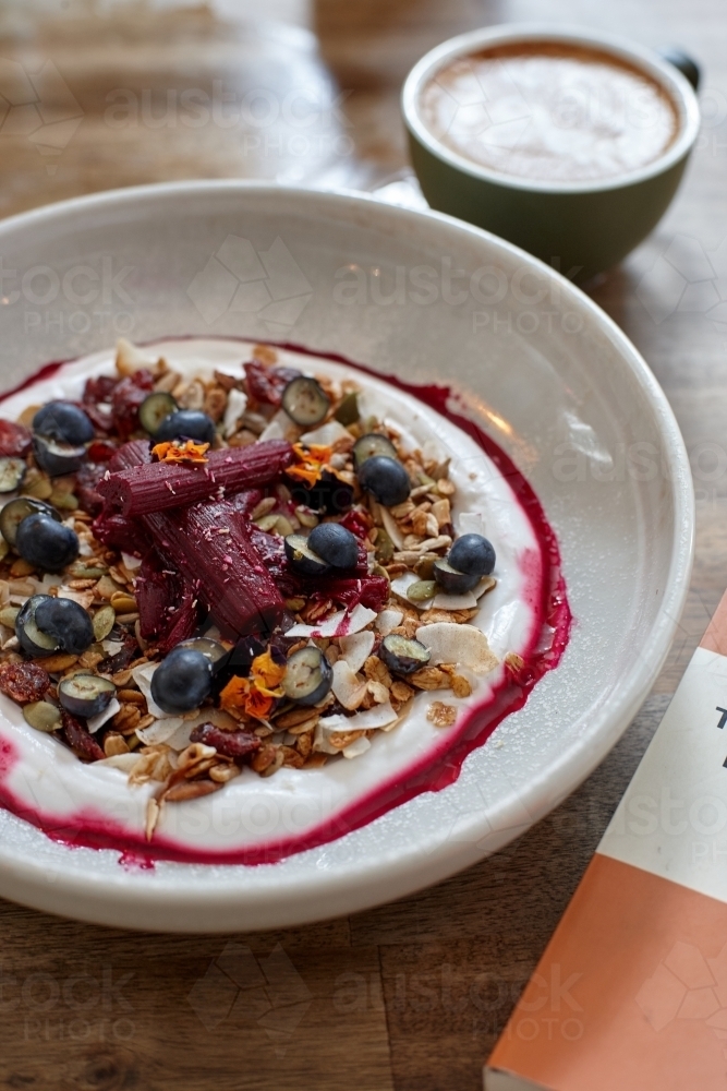 Healthy porridge served with hot beverage in vegetarian cafe - Australian Stock Image