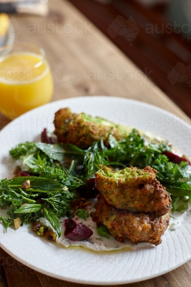 Healthy vegetarian falafel and salad dish on wooden table - Australian Stock Image