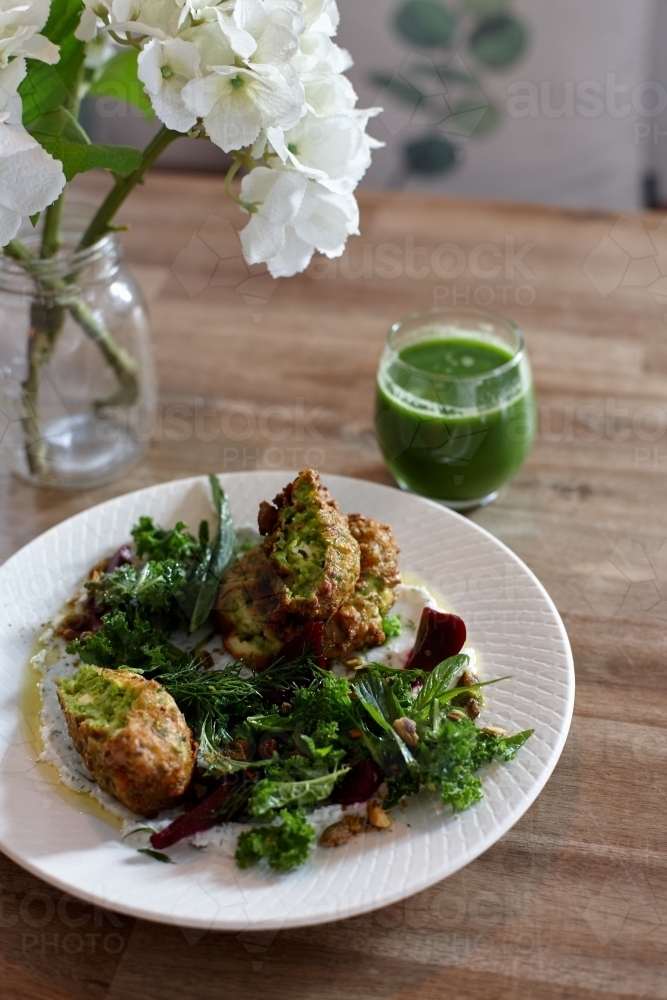 Healthy vegetarian falafel and salad dish on wooden table - Australian Stock Image