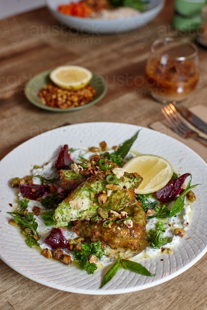 Healthy vegetarian falafel and salad dish on wooden table - Australian Stock Image