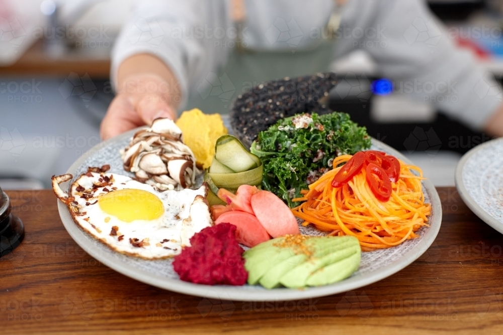 Healthy vegetarian meal being served on table - Australian Stock Image