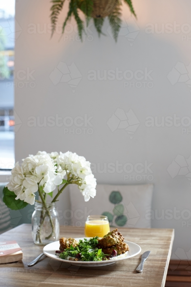 Healthy vegetarian meal on wooden table in vegan cafe - Australian Stock Image