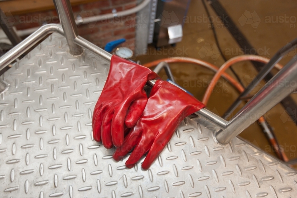 Heavy duty gloves hanging from a platform at a microbrewery - Australian Stock Image