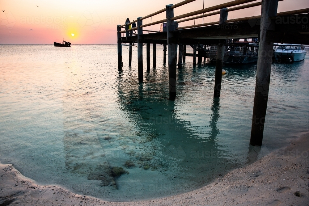 Heron Island Jetty at sunset with calm water in the foreground - Australian Stock Image