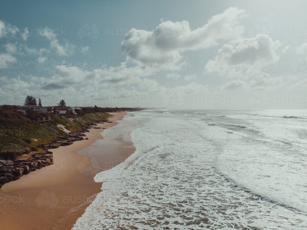 High angle shot of waves crashing on a deserted beach - Australian Stock Image
