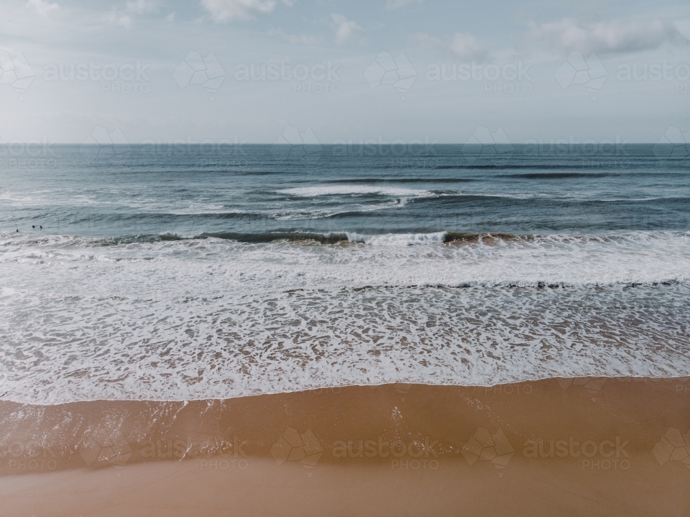 High angle shot of waves crashing on a deserted beach - Australian Stock Image