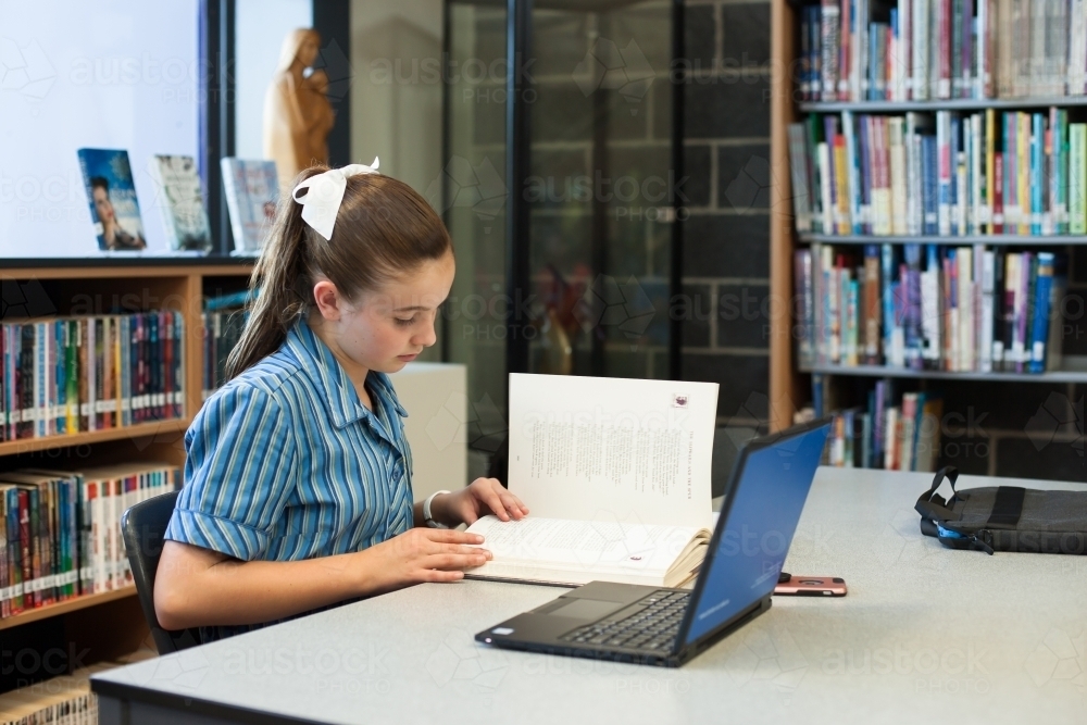High school student studying in a library - Australian Stock Image