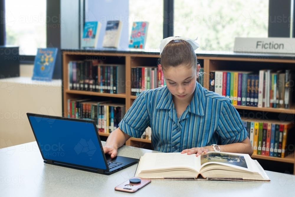 High school student studying in a library - Australian Stock Image