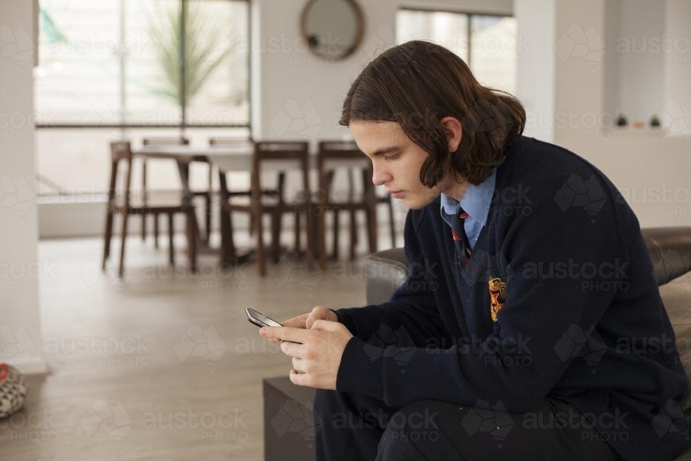 High school student using smart phone at home - Australian Stock Image