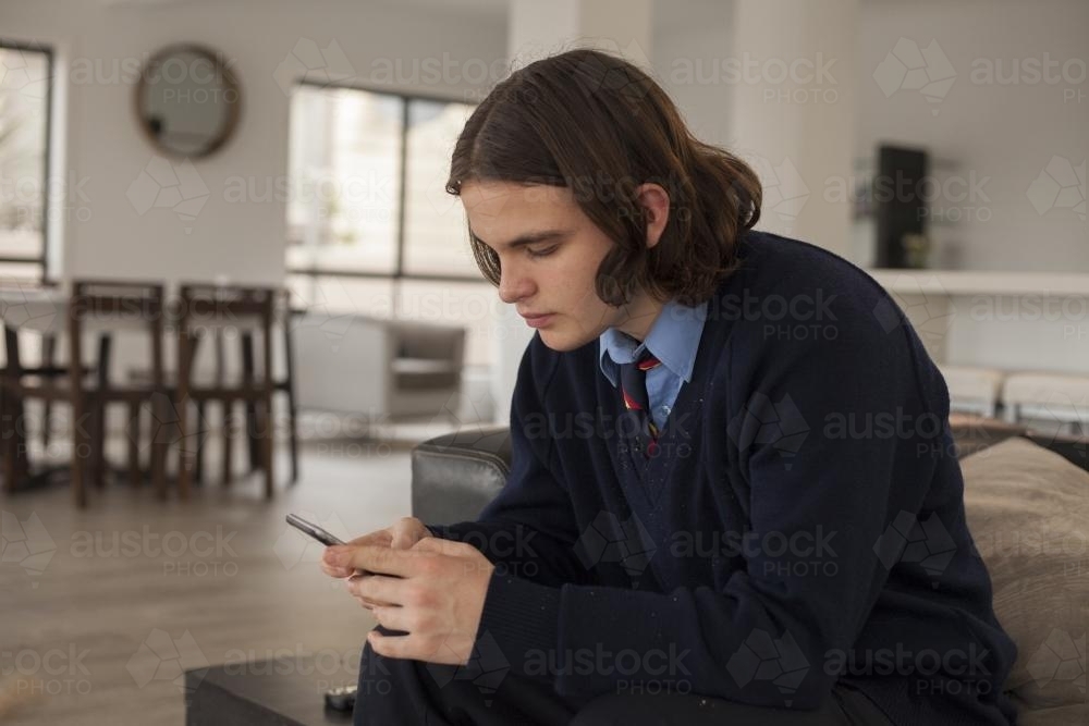 High school student using smart phone at home - Australian Stock Image