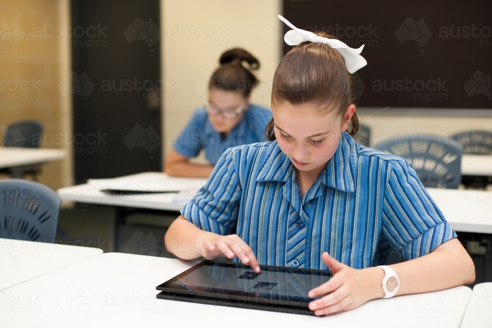 High school student working on tablet in a classroom - Australian Stock Image