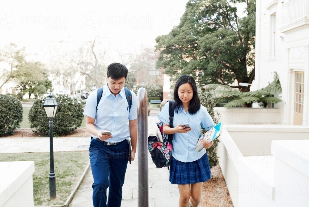 High School students walking together with phones - Australian Stock Image
