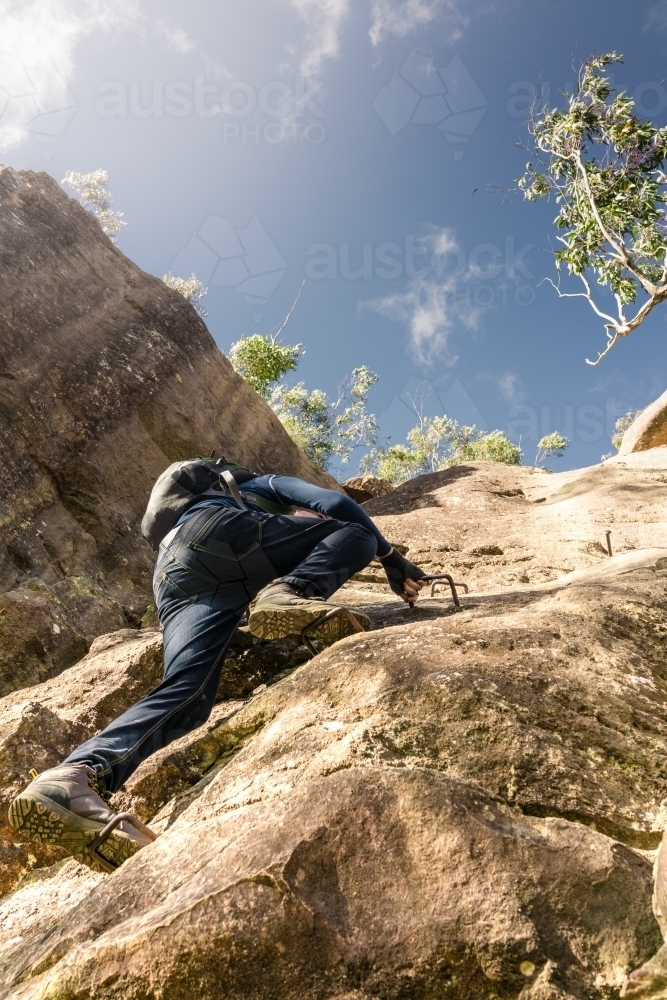 Hiker climbing an escarpment in the Blue Mountains - Australian Stock Image