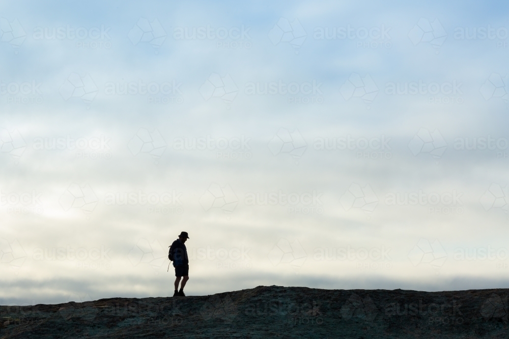 Hiker in distance silhouetted against sky - Australian Stock Image