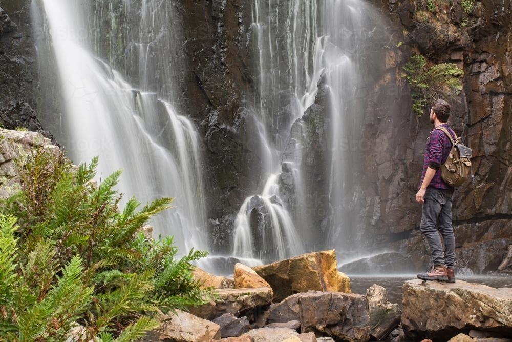 Hiker in front of waterfall - Australian Stock Image