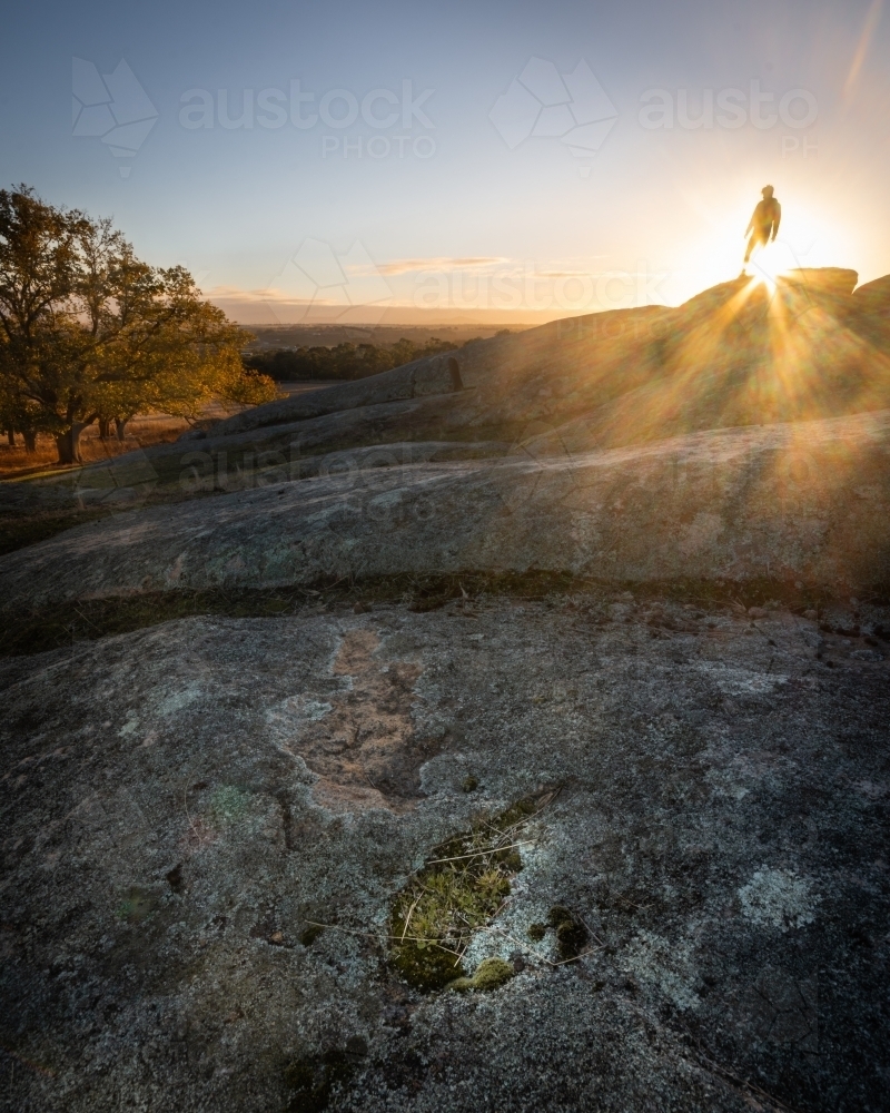 Hiker on a Rocky Mountain Peak at Sunrise - Australian Stock Image