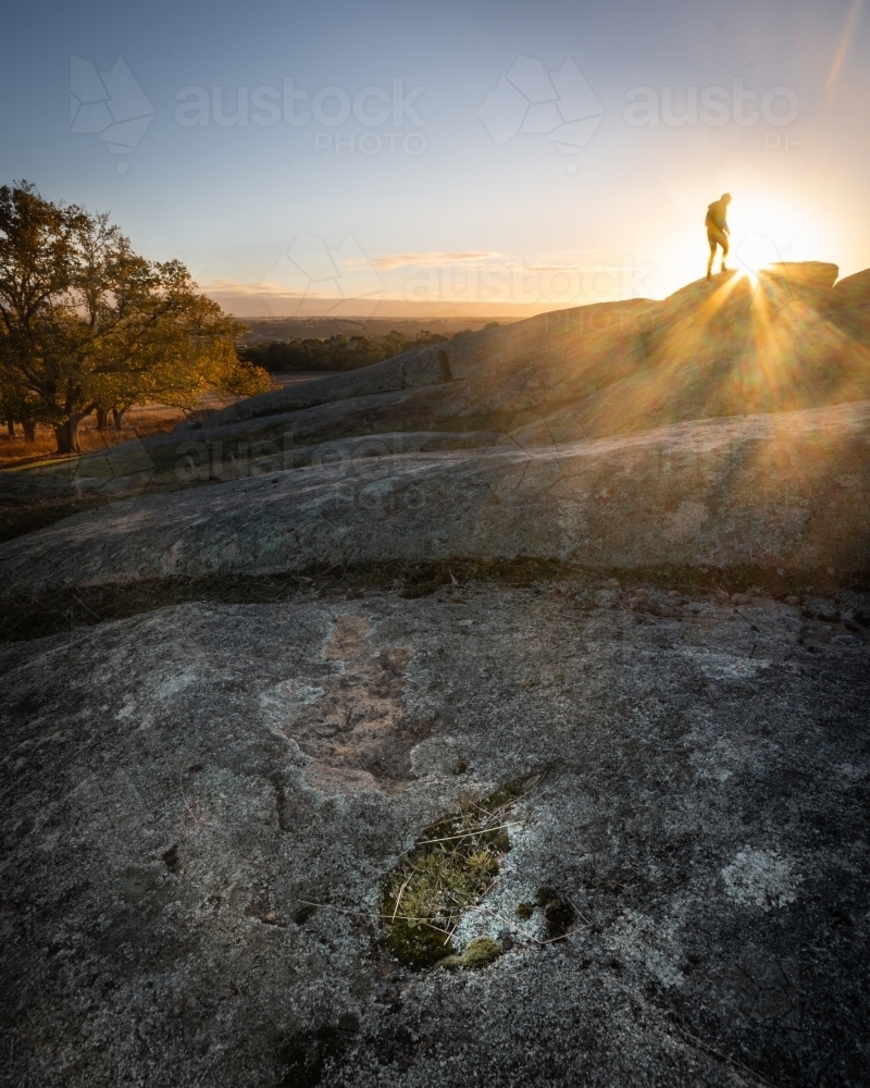 Hiker on a Rocky Peak at Sunrise - Australian Stock Image
