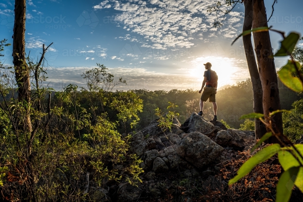 hiker stands overlooking a wilderness scene - Australian Stock Image