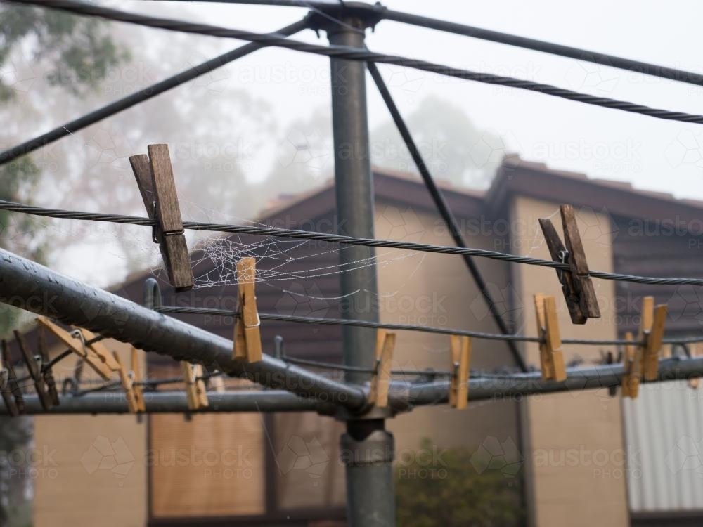 Hills hoist clothes line with pegs and spider web - Australian Stock Image